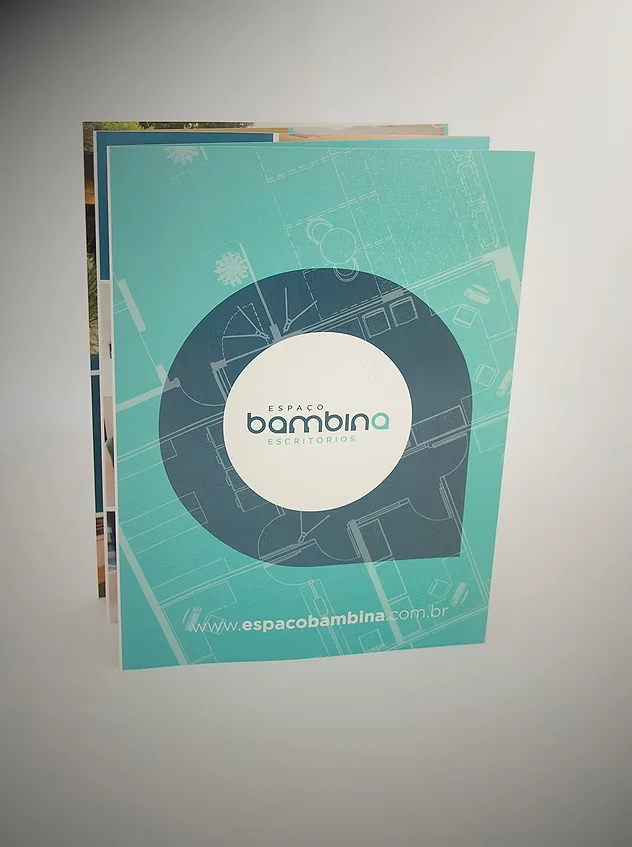 Espaço Bambina Escritórios brochure cover in aqua green, with the brand inside a speech bubble over the floor plan.