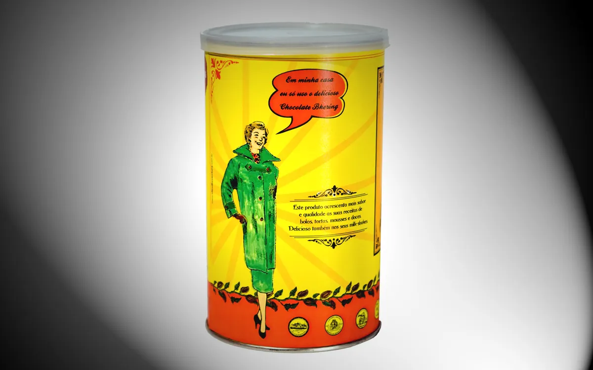 Yellow tin of Bhering cocoa powder with an illustration of a woman in a green coat and a speech bubble.